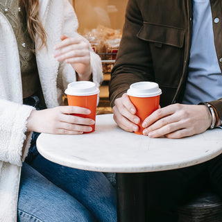 Couple drinking coffee outside a bakery