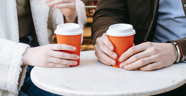 Couple drinking coffee outside a bakery